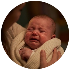 A distressed baby calming down immediately after a sound machine is turned on
