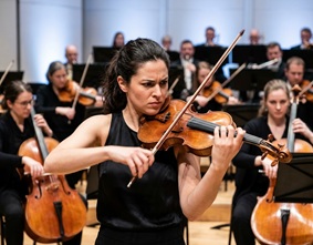 A musician passionately playing a classic wooden violin