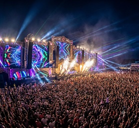 Fireworks exploding over an enormous EDM festival stage