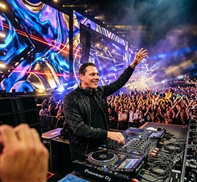 Ti&euml;sto raising his hands to a massive festival crowd