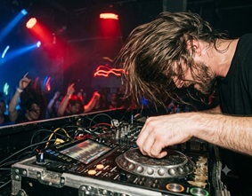 A dark, intense underground rave setting with lasers