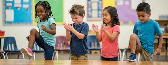 Toddlers stomping their feet and clapping hands to a rhythm
