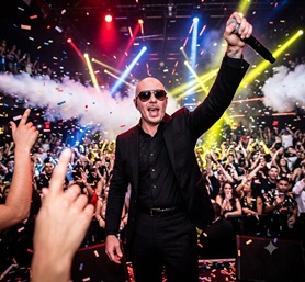 Pitbull performing live with sunglasses in a high-energy concert