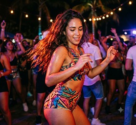 A tropical beach party at night with dancing crowds