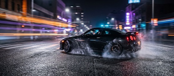 View from inside a sports car driving fast on a neon-lit highway