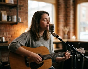 An acoustic guitar and a microphone on a stool