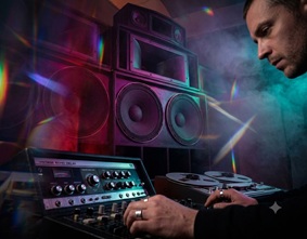 A DJ mixing board with heavy bass speakers