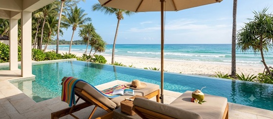 A person relaxing on a sunny beach with headphones