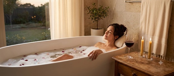 A relaxing bubble bath with lit candles and a glass of wine