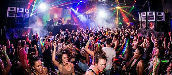 A vibrant nightclub crowd jumping under intense strobe lights